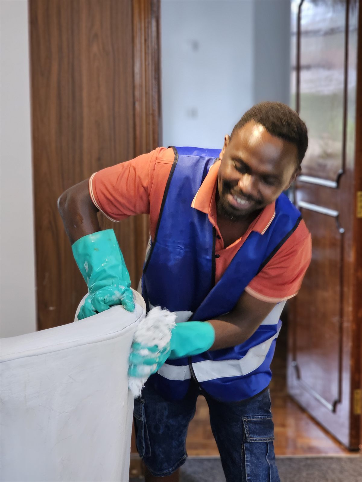 Close-up of an OnyxHawk crew member cleaning upholstery in protective gloves